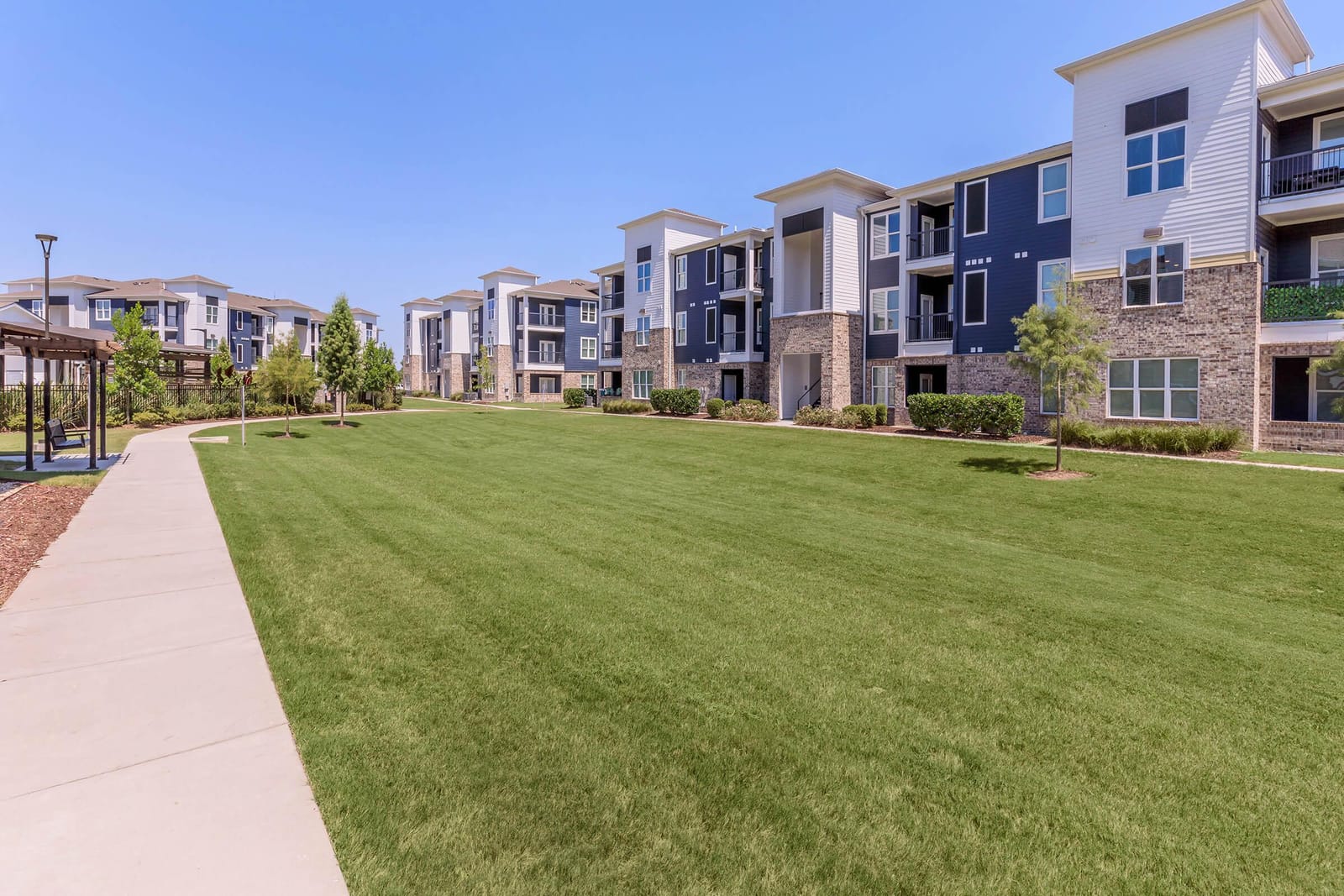Three-story apartment buildings and lawn at Waters at Manhattan in Harvey, Louisiana